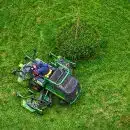 green and black ride on lawn mower on green grass field during daytime