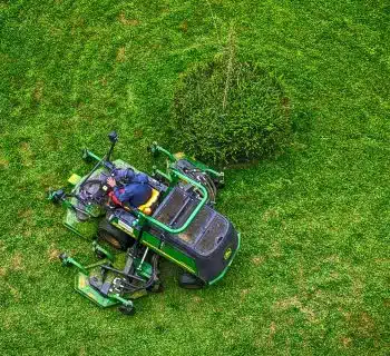 green and black ride on lawn mower on green grass field during daytime